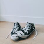 Two classic black sneakers with white shoelaces, perfect for casual style.